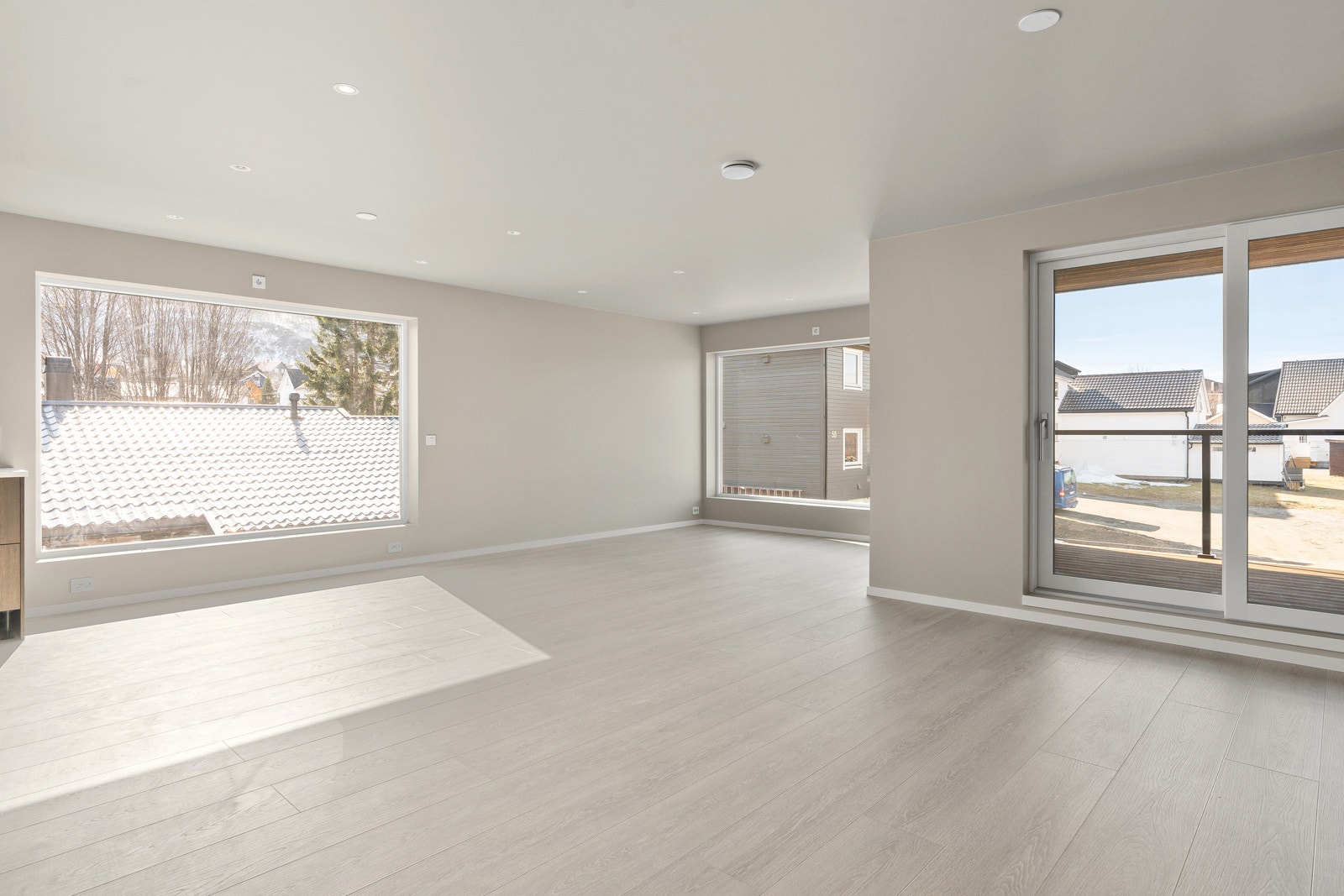 Lys og romslig stue. Vegg og tak i gips med listefri utførelse rundt vindu og tak.