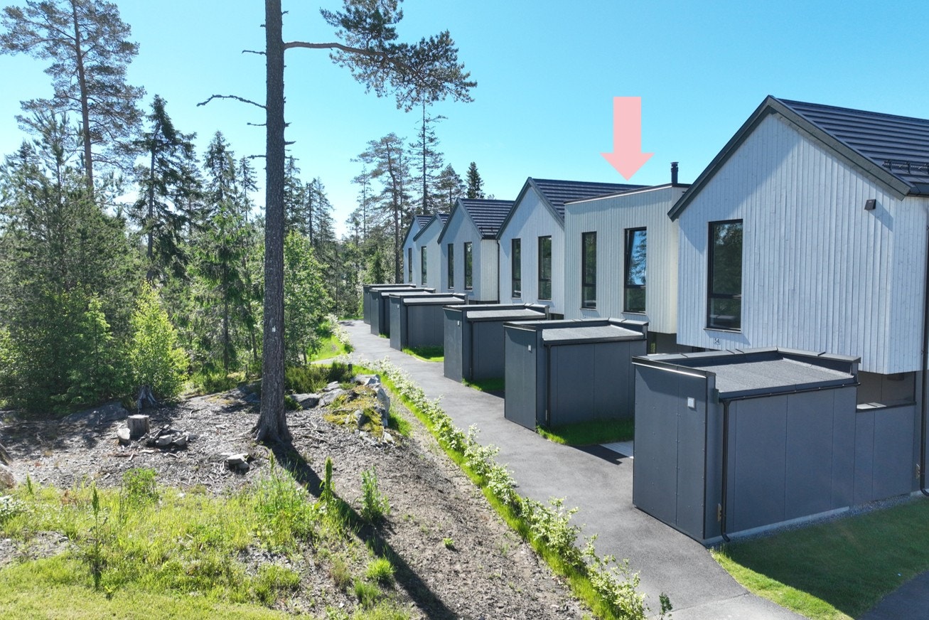 PÅ inngangssiden på huset er det flott natur og en koselig lekeplass for barna