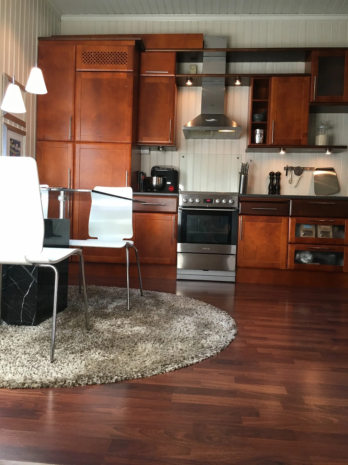 Kjøkken med induksjonsovn, kjøleskap og fryser + medfølgende kjøkkenbord og stoler. Galleribilde