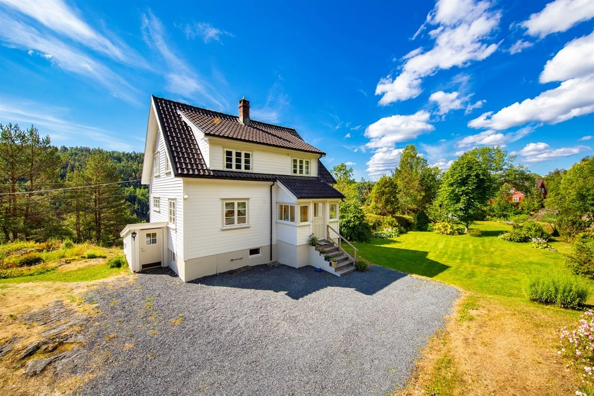 Hagen er pent opparbeidet med plen, naturstein, busker og trær. Galleribilde