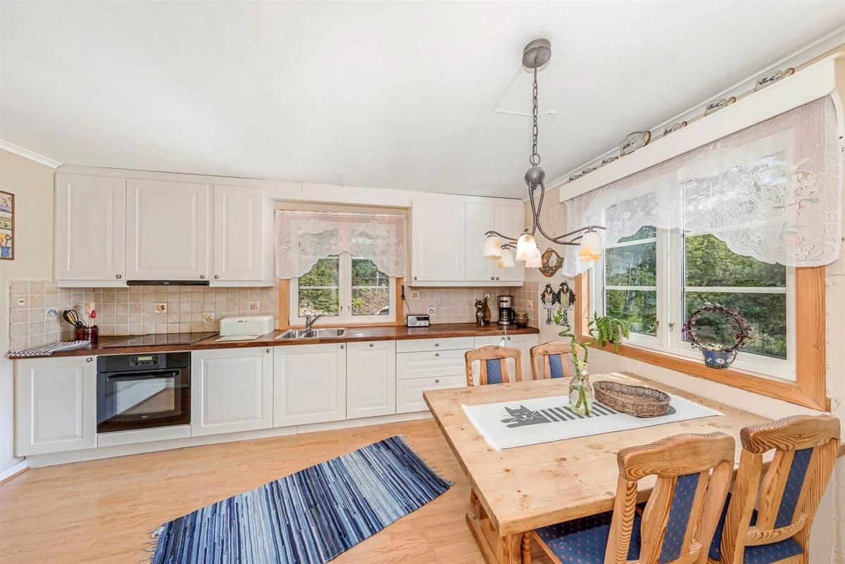 Kjøkkeninnredningen er fra Terna snekkeri og er spesialbygd med hvite, profilerte fronter og heltre benkeplate. Galleribilde