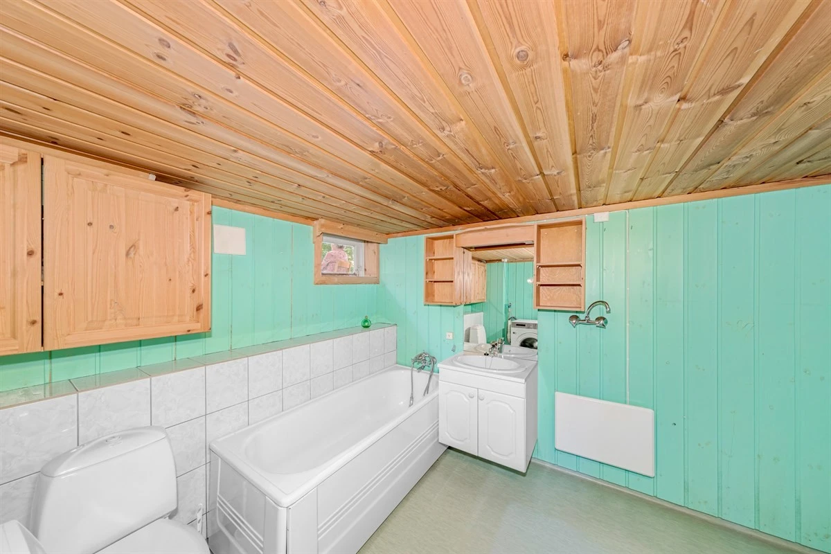 Badet har servant, toalett og badekar. Galleribilde