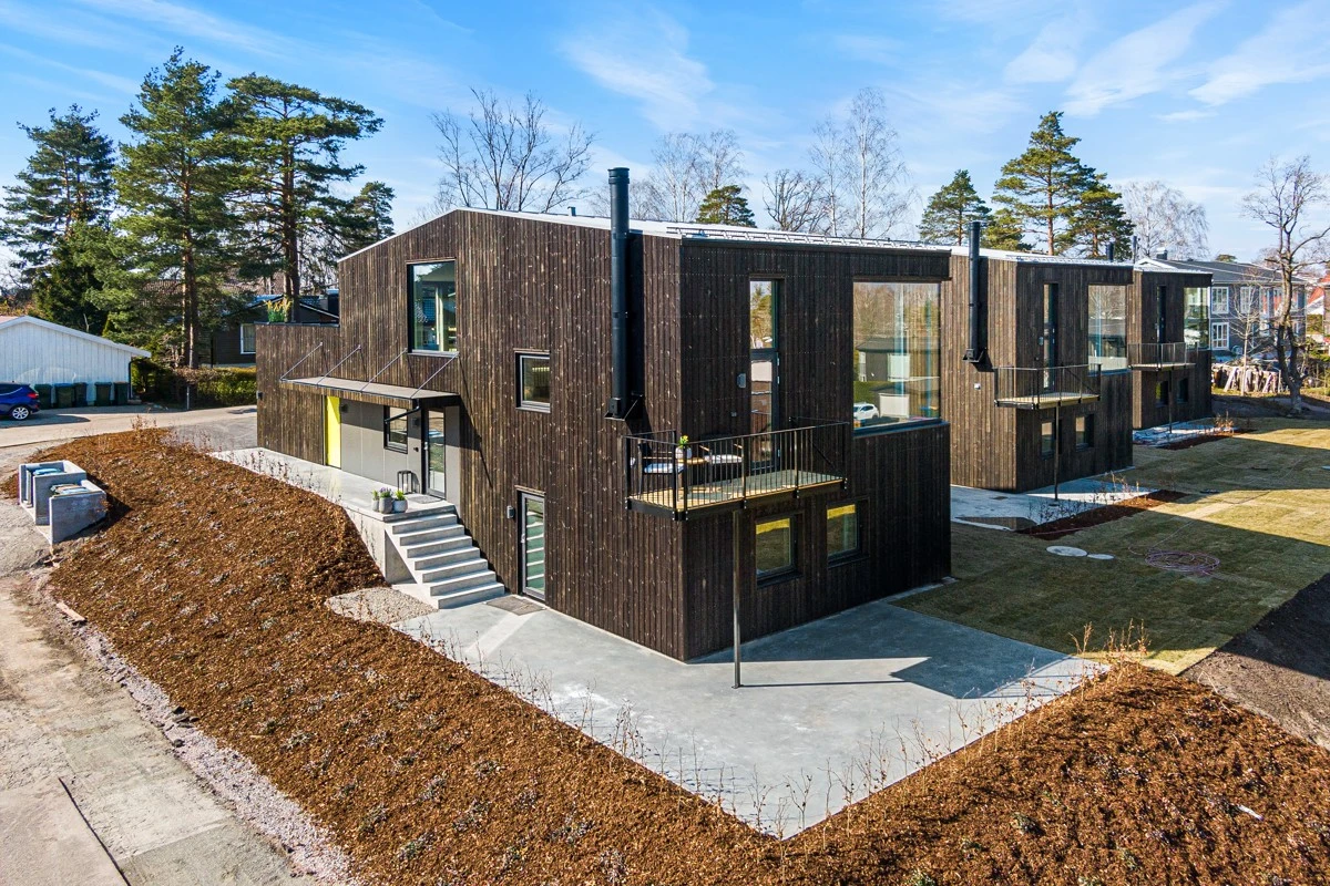 Tomten er pent opparbeidet med plen, betong og skrånede bed Galleribilde