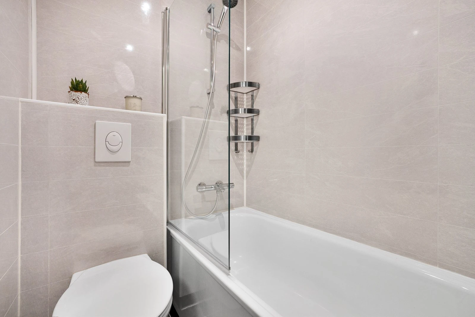 Badekar, veggmontert wc og flislagt bad med varmekabler Galleribilde