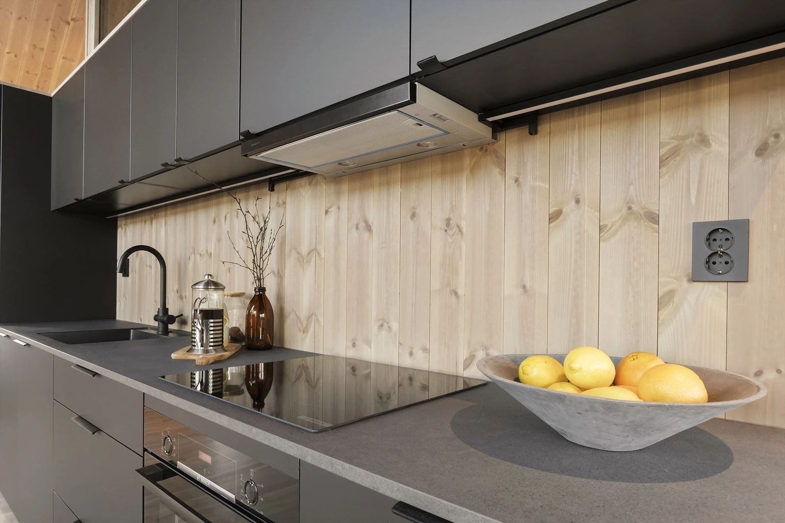 Velutstyrt kjøkken med integrerte hvitevarer fra Bosh med induksjon platetopp, komfyr, oppvaskmaskin og kjøleskap med frysedel. Galleribilde