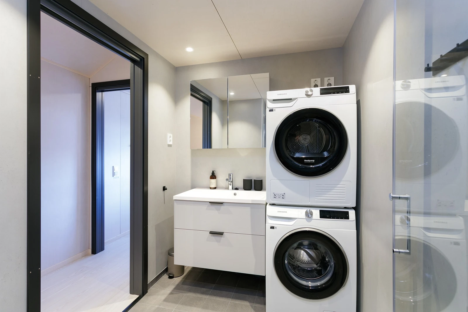 Bad med flislagt gulv, baderomsplater på vegger og himlinger i x-finer. Innredning med skuffer og nedfelt servant, veggmontert toalett, dusjhjørne med vegger. Opplegg for vaskemaskin. Det er balansert ventilasjon Galleribilde