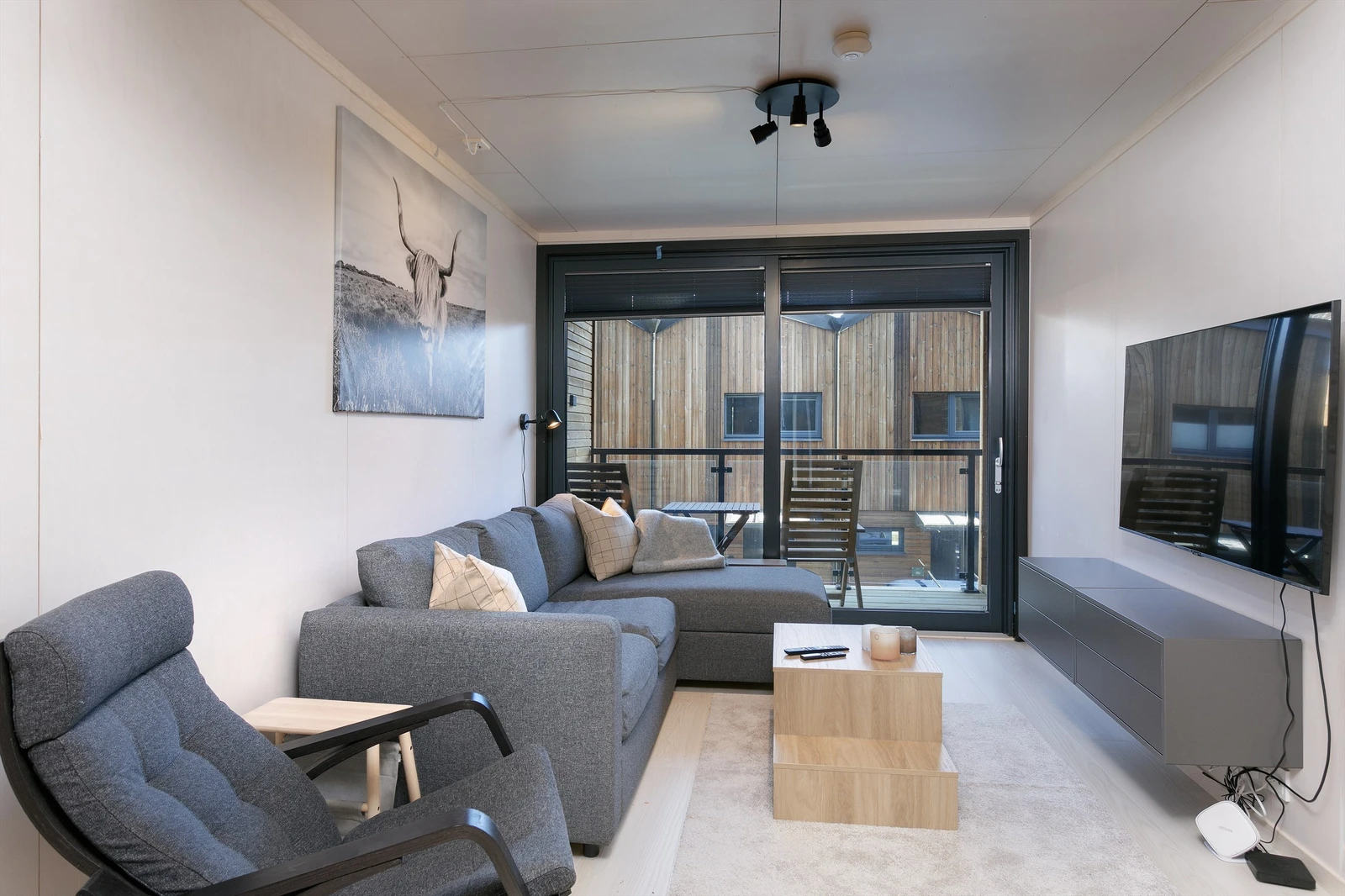 Det er utgang fra stue til inntrukket balkong med glassrekkverk Galleribilde