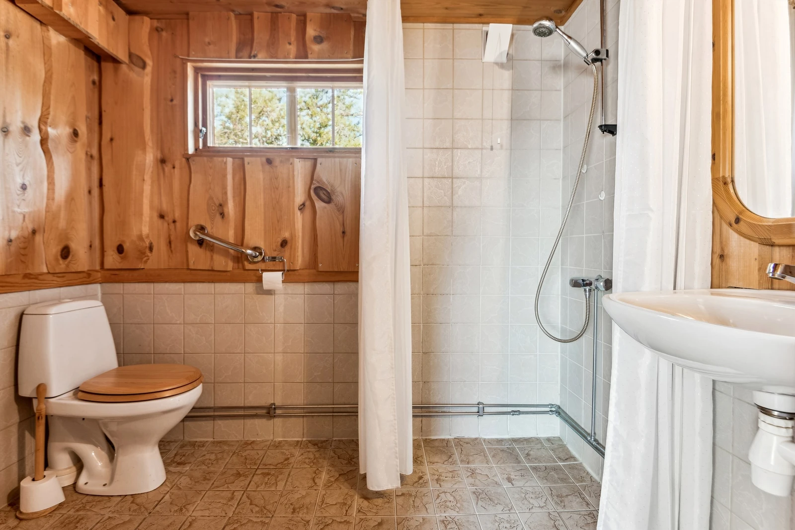 Badet har gulvfliser og vegger med fliser og ukantet panel. Oppvarming med elektrisk gulvvarme. Galleribilde