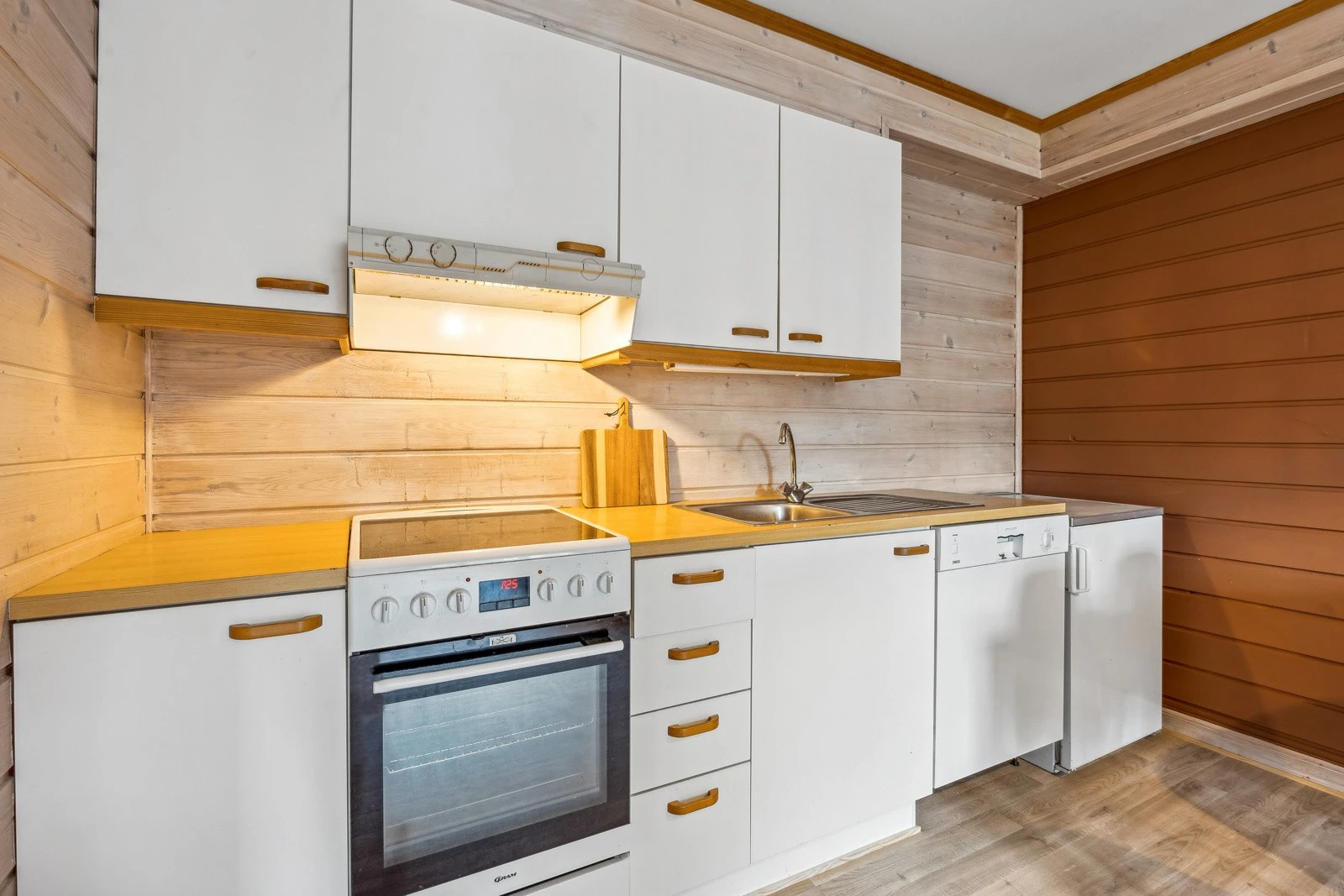 Kjøkkenet er utstyrt med frittstående komfyr, oppvaskmaskin og kjøleskap med fryser. Galleribilde