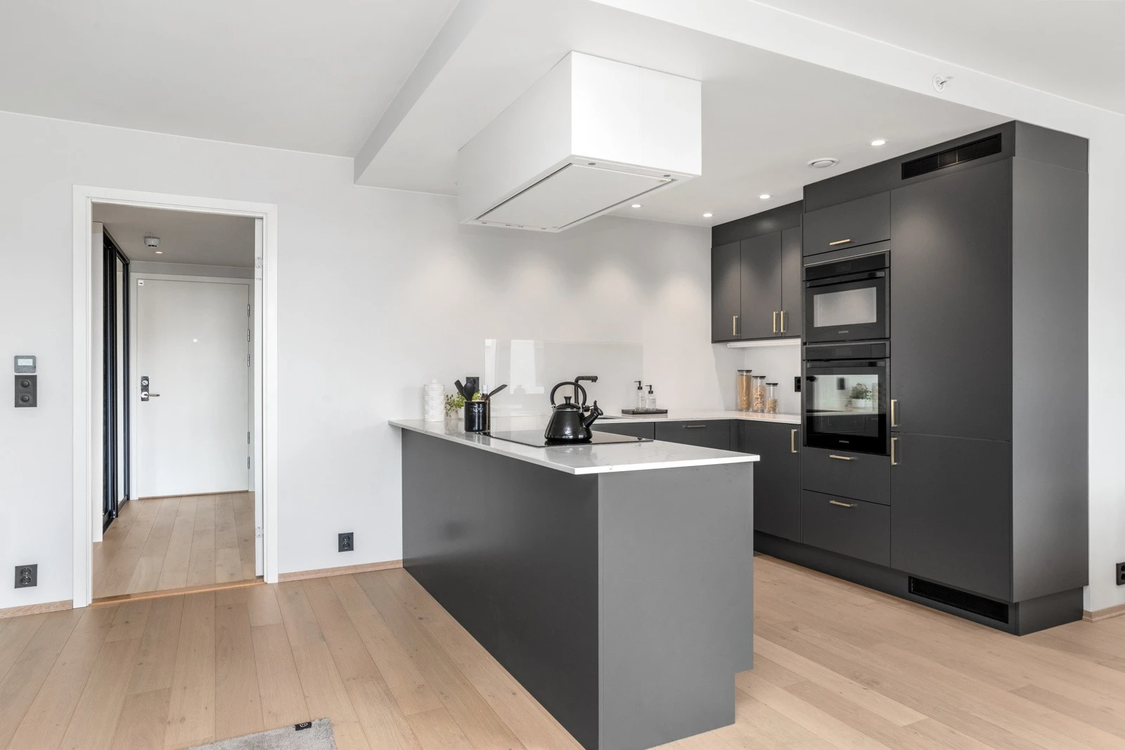 Elegant kjøkkeninnredning med slette fronter og lekker benkeplate av solid kompositt Galleribilde