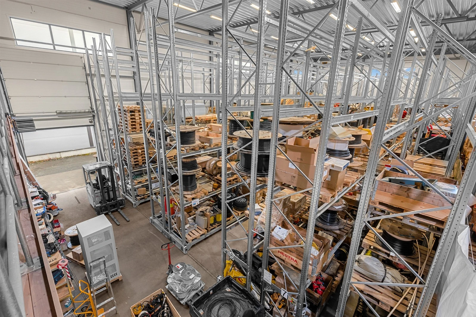 Ledig høytlager (30 x 15 meter) har ca. 10 meter takhøyde. Kjørteport er ca. 3x4 meter (bredde x høyde). Lageret er i dag utstyrt med et mobilt reolsystem for effektiv lagring, kan evt. tas ut. Galleribilde