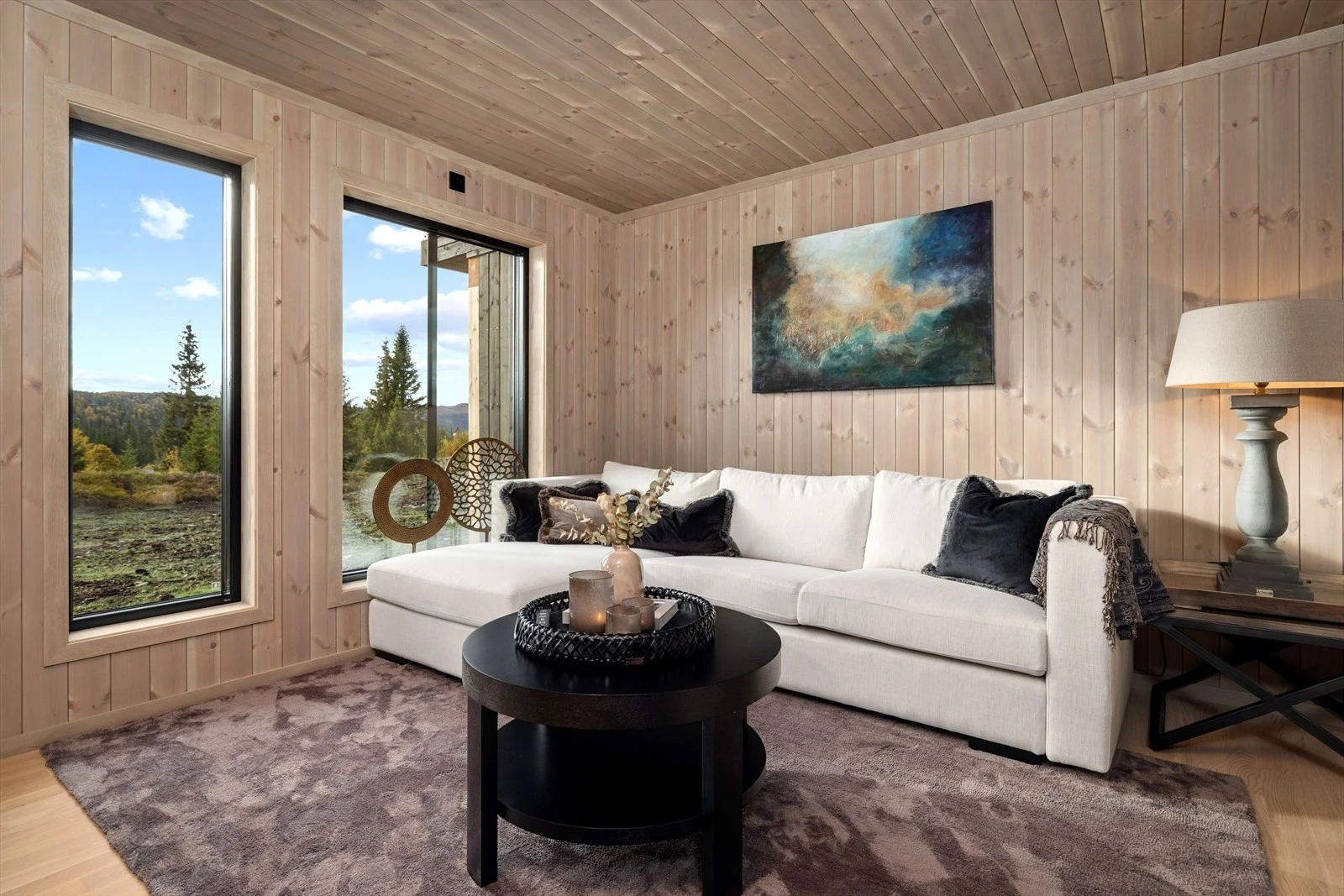 Stuen har store vindusflater og fin utsikt mot nærliggende grøntområder. Galleribilde