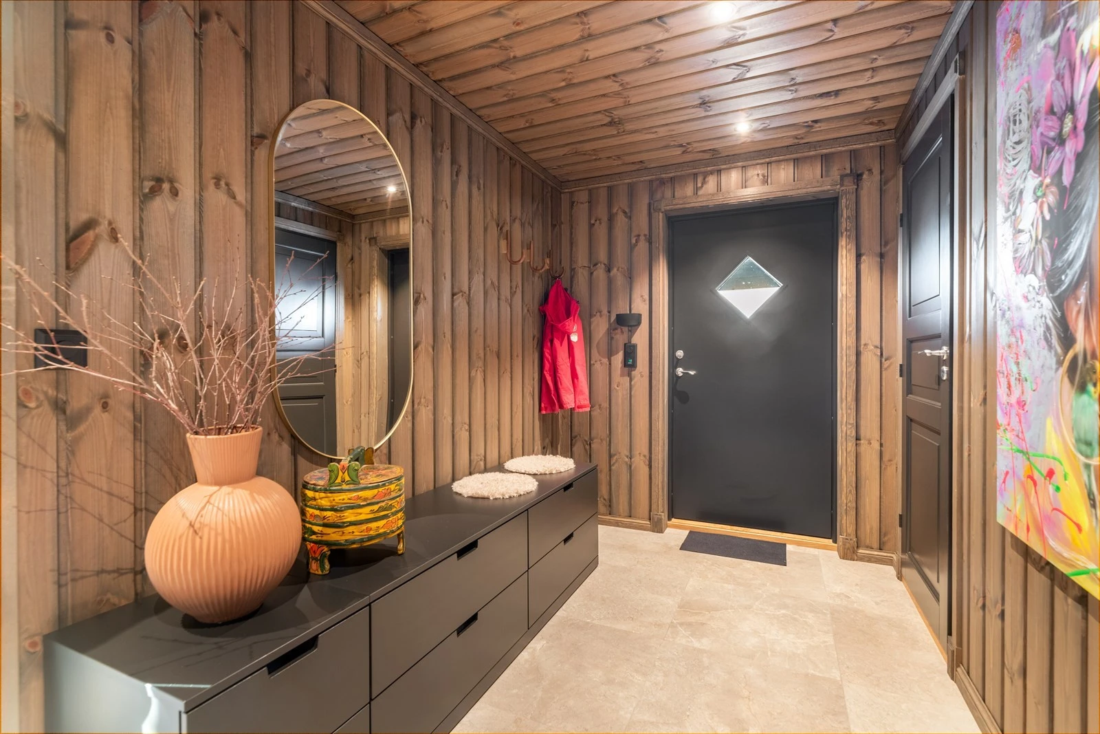 En romslig gang ønsker deg velkommen inn i hytta hvor det er flis på gulv med gulvvarme. Fin plass til sko og yttertøy samt oppbevaringsmøblement. Galleribilde