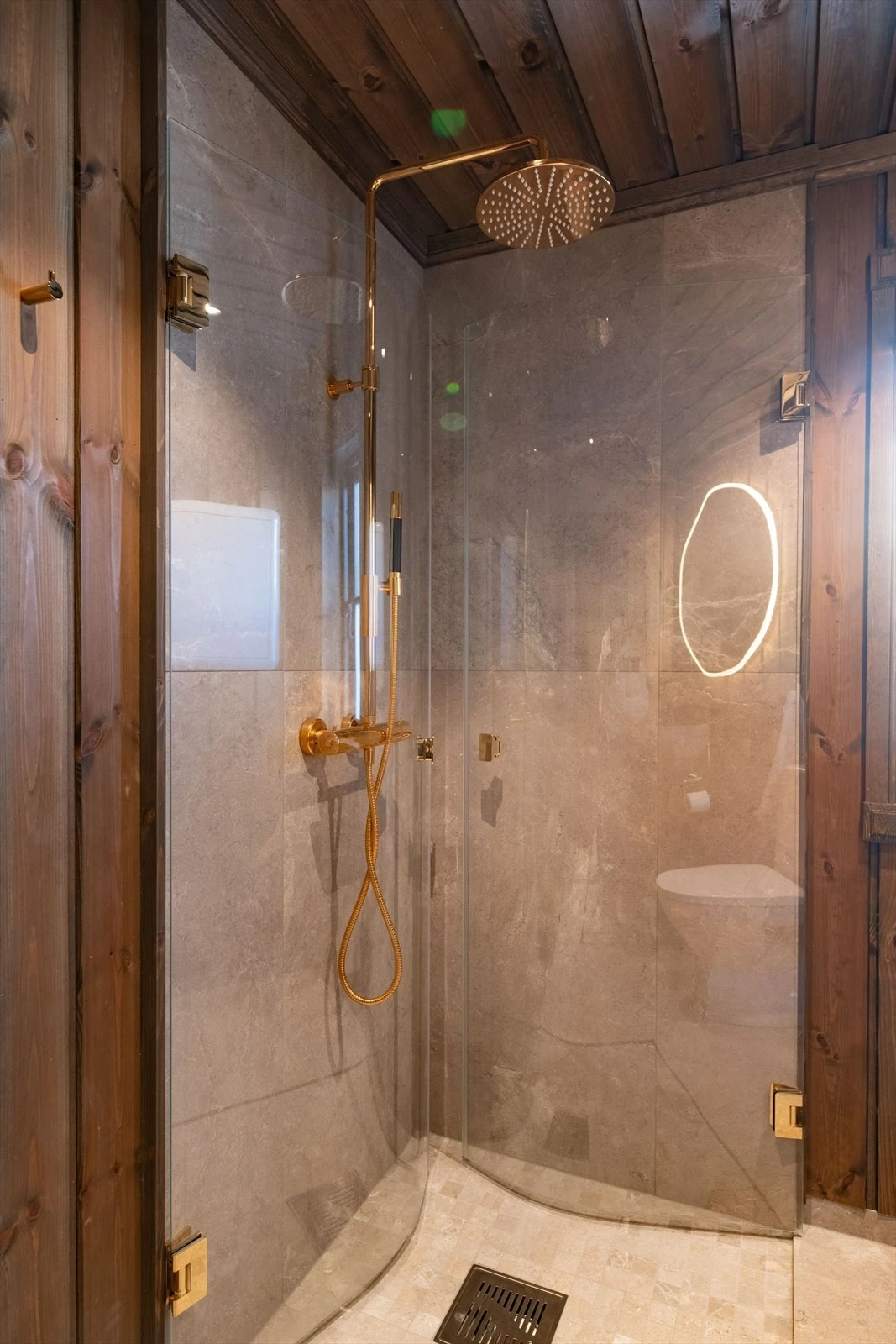 Flott, nedsenket dusjnisje med flis på gulv og vegger og glassdører i front som er innfellbare. Pent dusjarmatur på vegg. Galleribilde