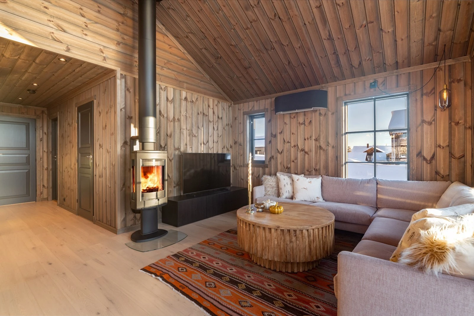 Hytta har en romslig stue med plass til både en spisestueavdeling naturlig mot kjøkkenet og sofagruppe ved den deilige peisovnen. Peisovnen har glassflater som gir et lunt preg og god varme på kalde dager. Galleribilde