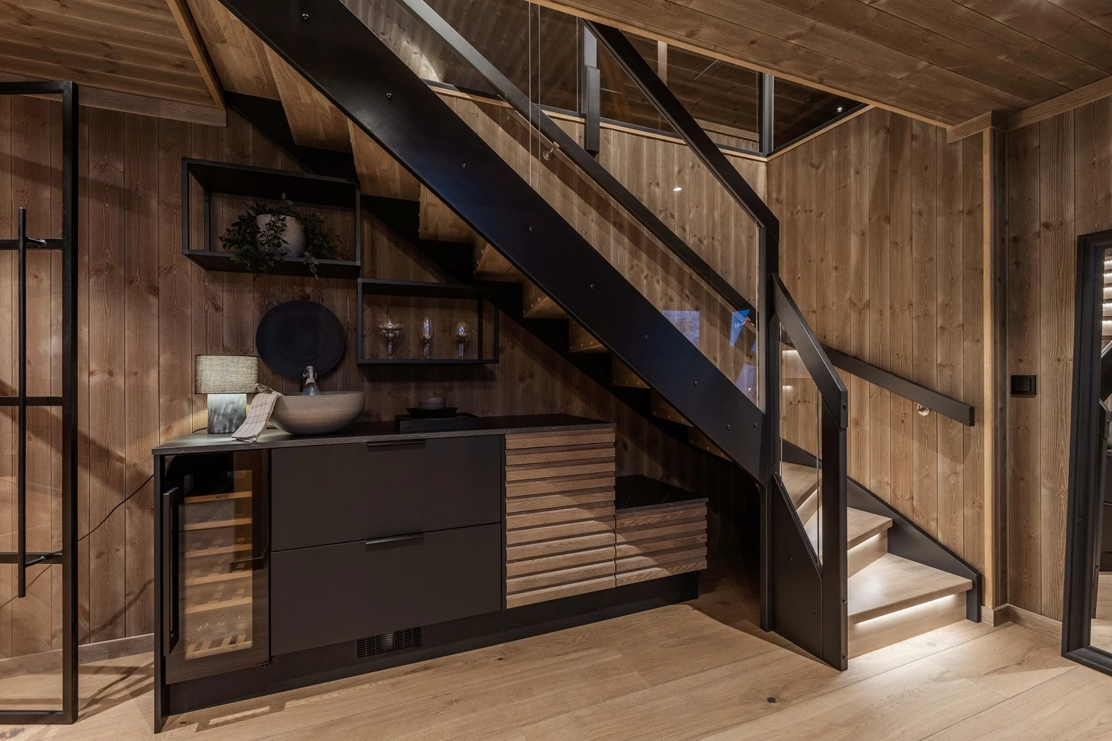 Under trappen er det installert møbel med benkeplate og integrert vinskap med plass for 20 flasker og seksjon med to kjøleskuffer med temperaturregulering. Galleribilde