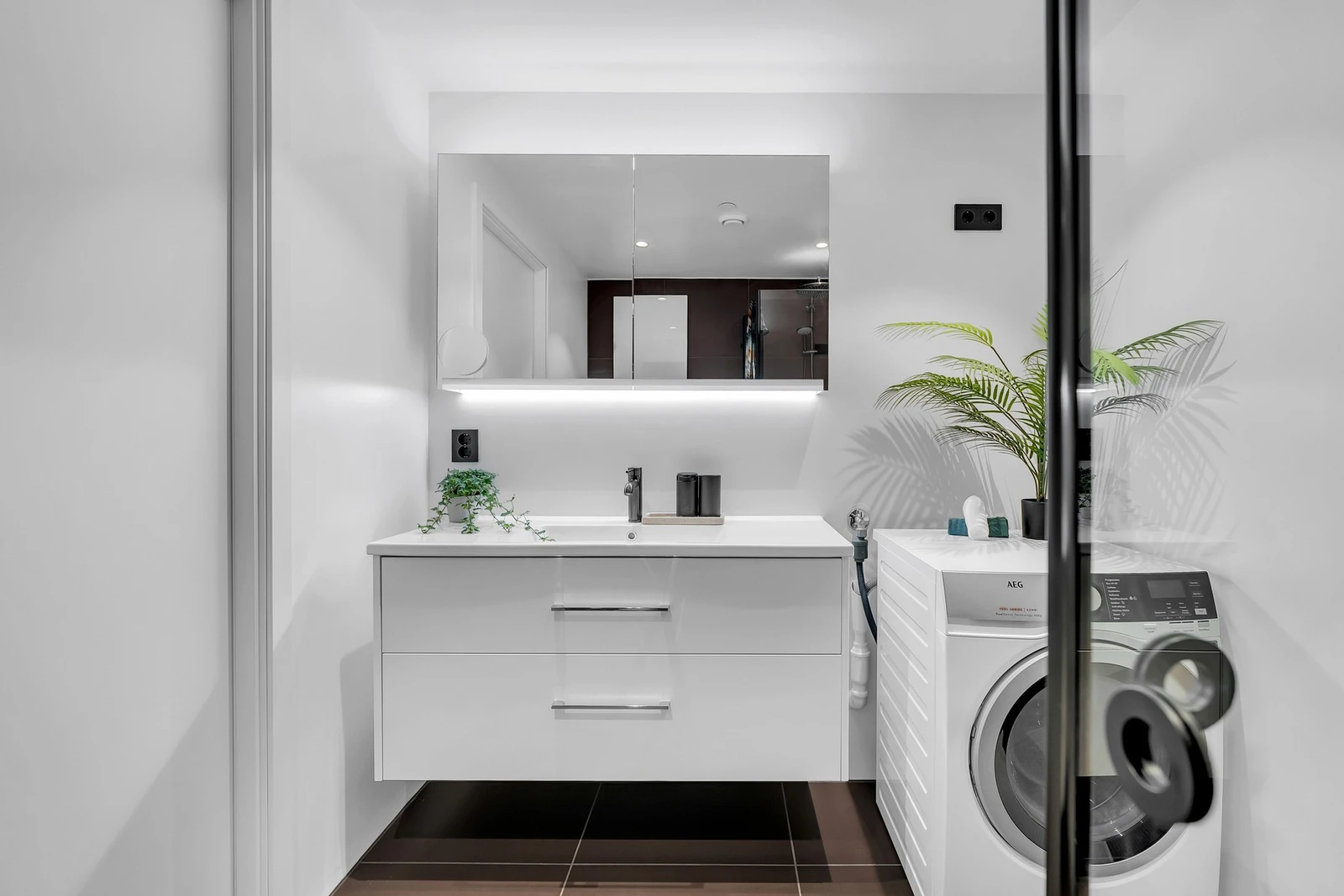 Rommet har innredning med nedfelt servant, veggmontert toalett, dusjvegger/hjørne og opplegg for vaskemaskin. Galleribilde