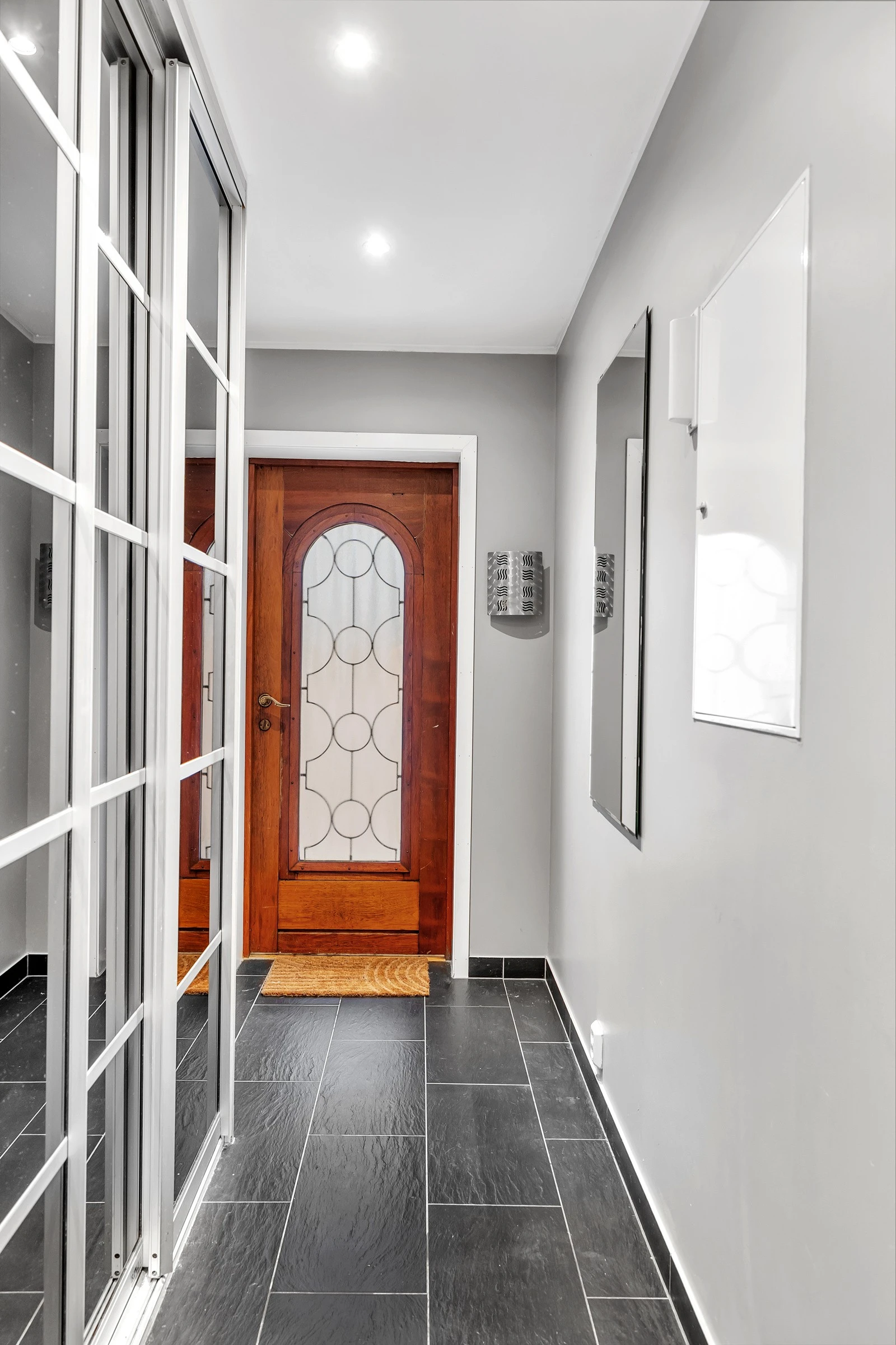 Velkommen inn! Det første som møter deg er denne flislagte gangen hvor det er montert praktisk skyvedørsgarderobe Galleribilde