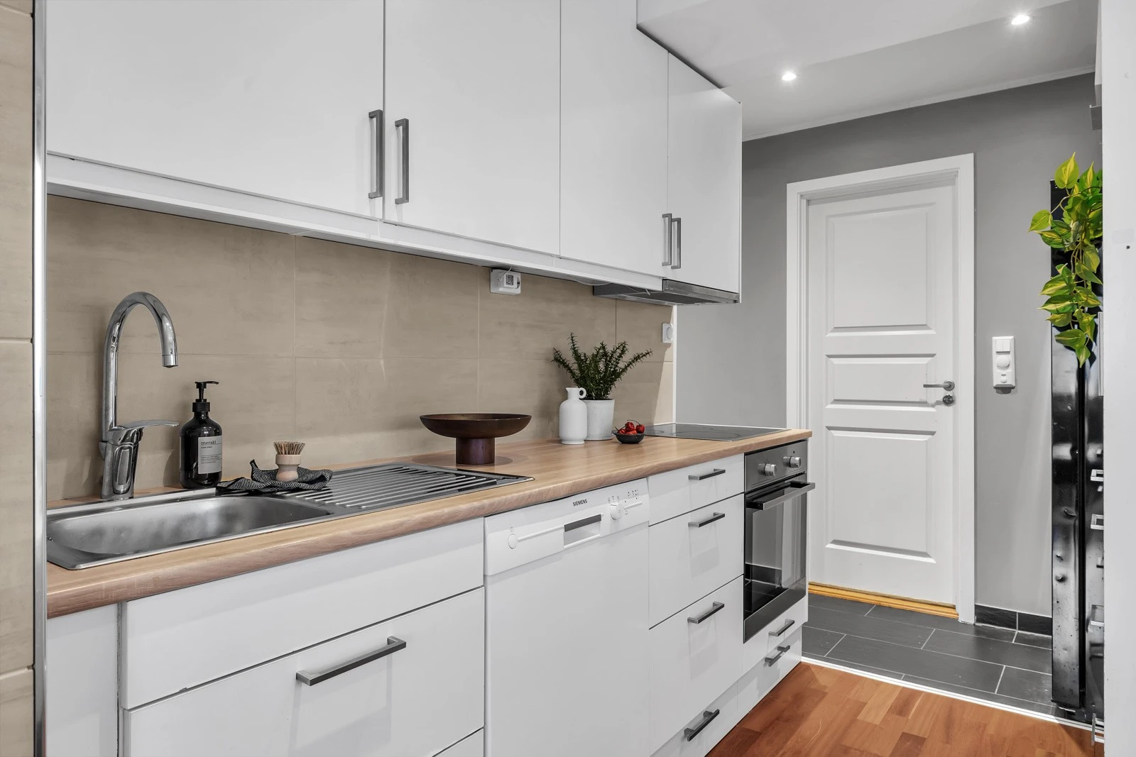 Kjøkkenet er i hvit slett utførelse Galleribilde