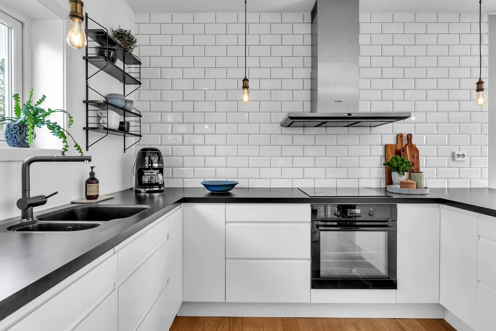 Moderne og pen innredning med glatte hvite fronter og sorte detaljer Galleribilde