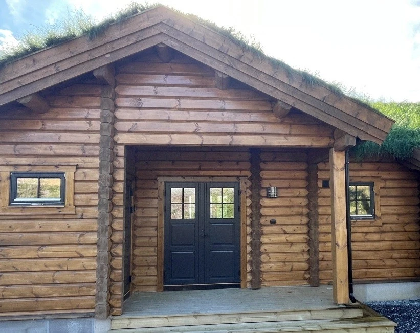 Hytta har et flott, praktisk inngangsparti som er skjermet fra vær og vind. Inngang til sportsbod til venstre for inngangsdør.
Foto viser kundevariant av Hummelfjell Pan 128 som står i Kyrkjebygdheia. Galleribilde