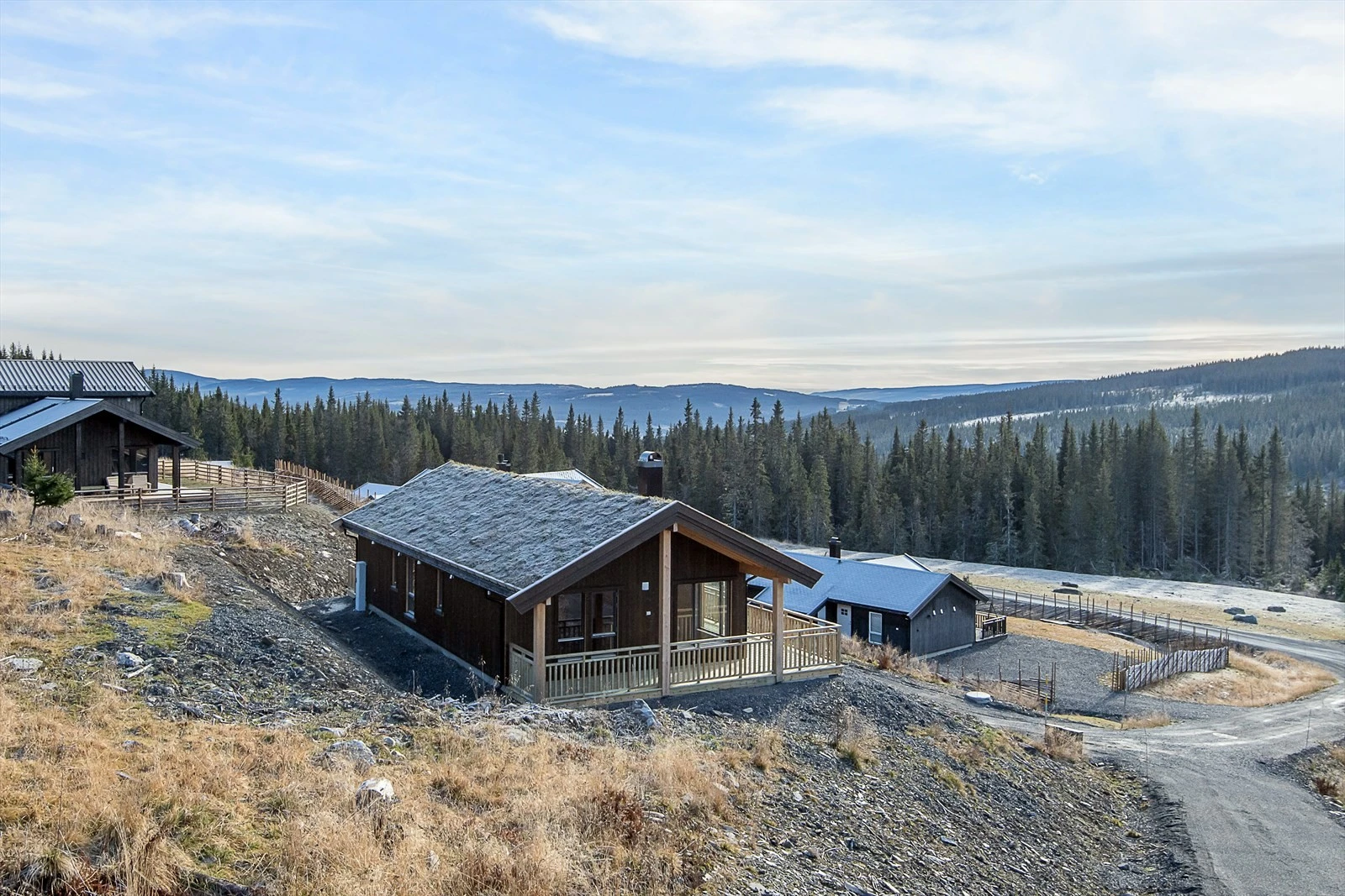 Skrånende tomt som er terrassert rundt bebyggelsen. Tomten leveres grovplanert og klar for påkjøring av matjord og tilsåing. Galleribilde