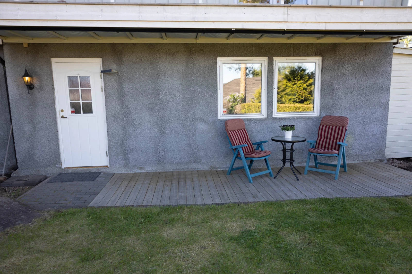 Liten platting til utemøbler, som står under tak. Galleribilde