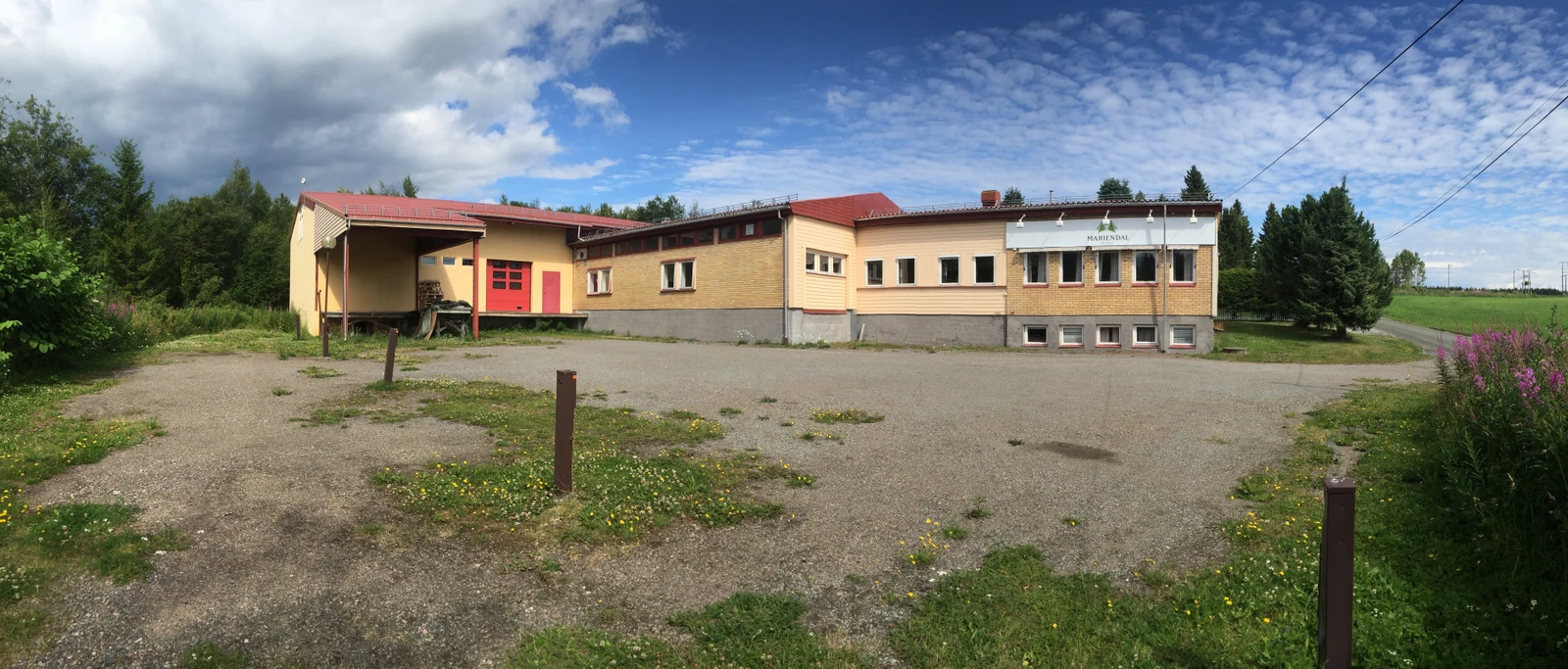 Nedsiden av bygget hvor varemottak for lastebiler og stor parkeringsplass Galleribilde