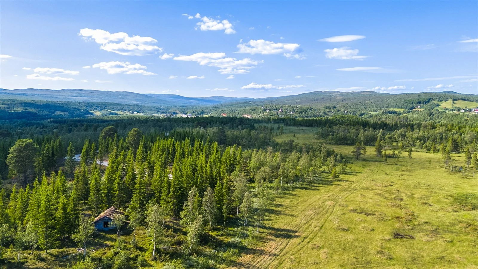 Skiløypa går like ved feltet, ute på myra. I bakgrunnen sees Glåmos kirke og Glåmos skole, samt Glåmos stasjon med Coop Marked. Galleribilde