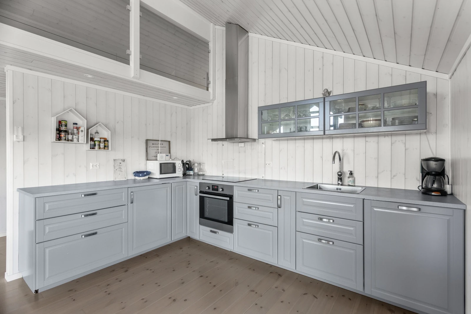 Lekker innredning med lysegrå, profilerte fronter og integrerte hvitevarer Galleribilde