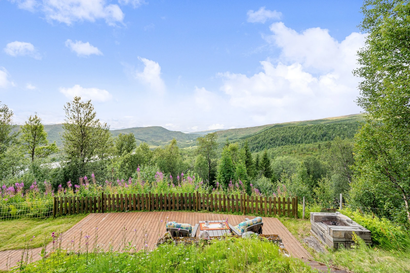 Hytten ligger høyt i terrenget og har flott utsikt over fjell og sjø Galleribilde