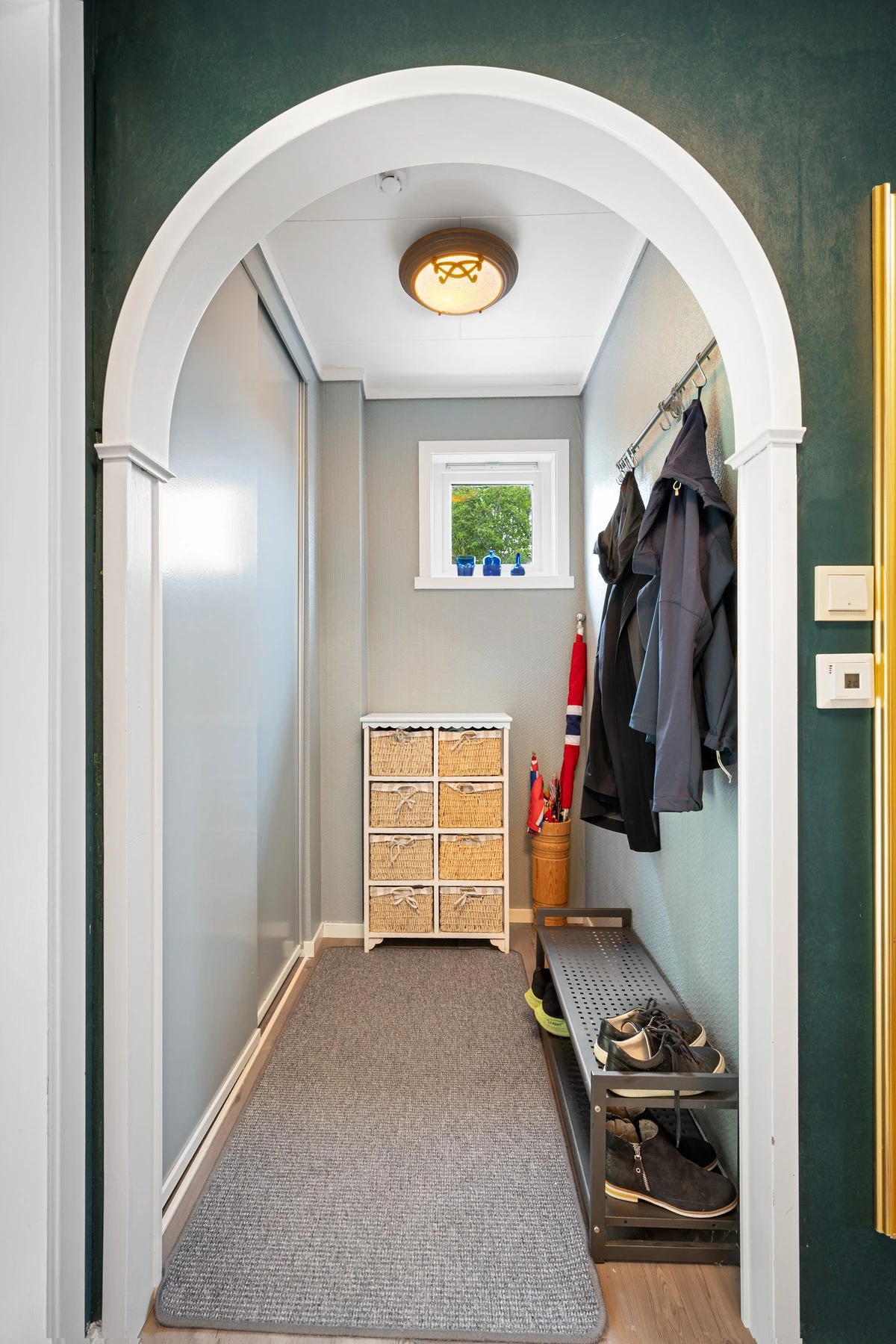 Smart løsning med adskilt rom i entré for oppheng av yttertøy både på knagger og i stor skyvedørsgarderobe Galleribilde