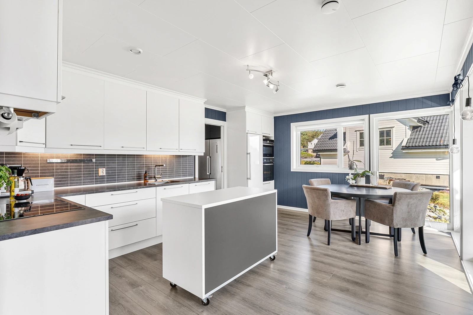 Stilren kjøkkeninnredning med slette fronter og benkeplate i laminat med stålvask. Galleribilde