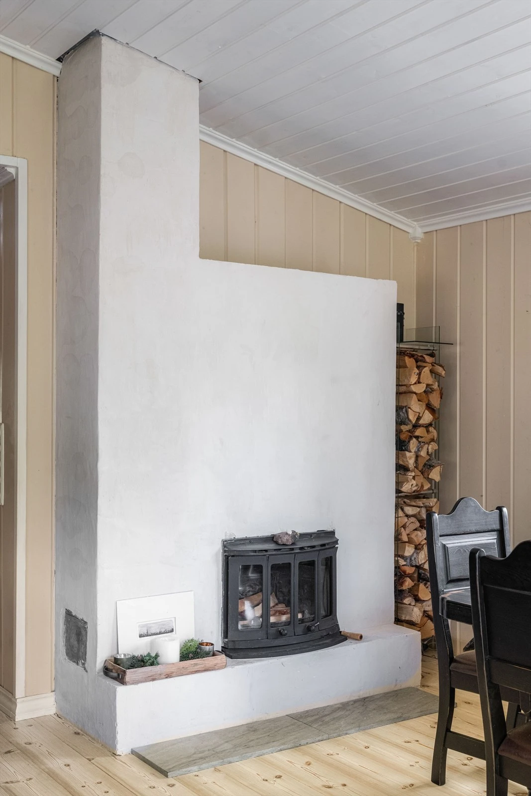 Stua har en koselig peis med peisinnsats og pyntehylle, og hvor det er god stableplass til ved på siden. Galleribilde