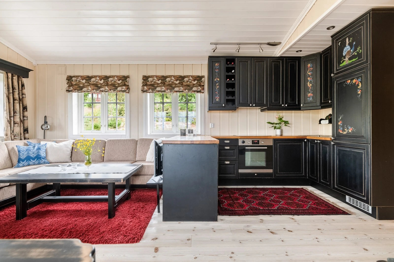 På kjøkkenet er det godt med skapplass i takhøy innredning i mørk utførelse. Benkeplaten er laminert, med nedfelt koketopp og oppvaskkum. Galleribilde