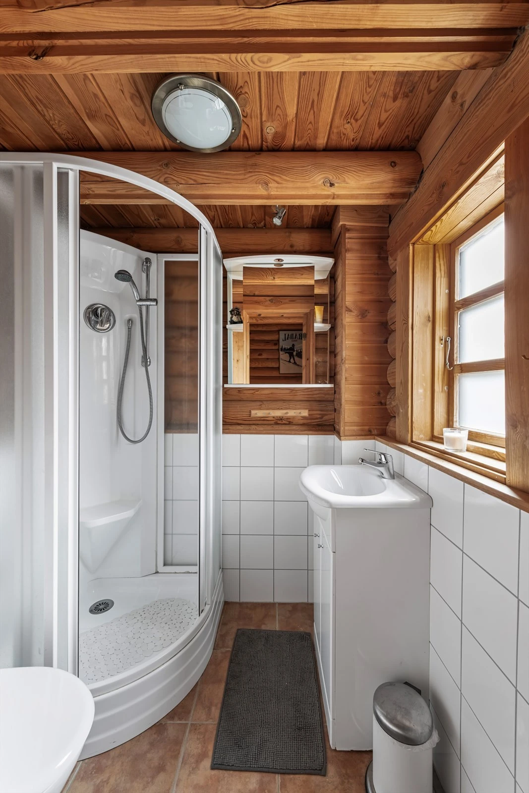 Badet er pent innredet med dusjkabinett, servant i innredning og toalett Galleribilde