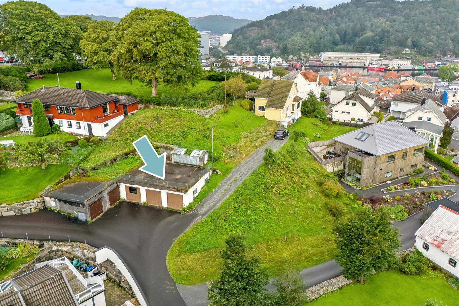 I tillegg til selve tomten følger det også med garasje med tre porter. Garasje med to porter til venstre står på nabotomten og følger naturligvis ikke salget. Galleribilde