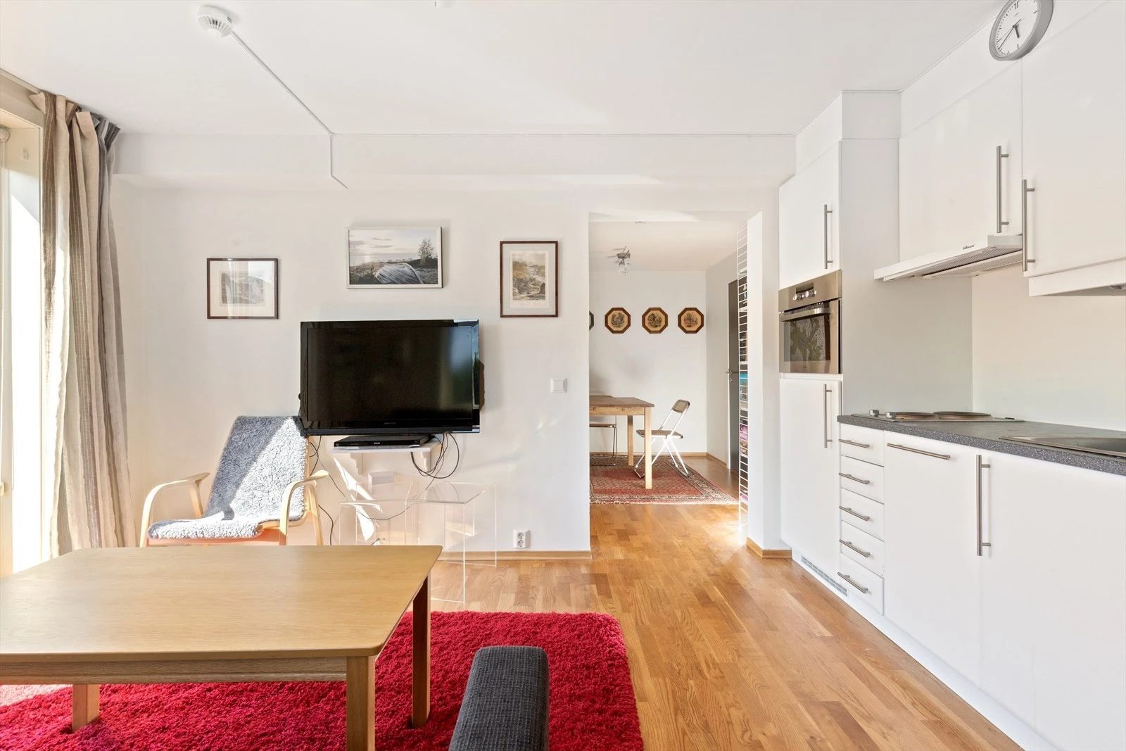 Takhøye skap, integrert ovn, kjøleskap og oppvaskmaskin, koketopp med to plater og et praktisk, innfellbart bord når man trenger mer benkeplass. Galleribilde