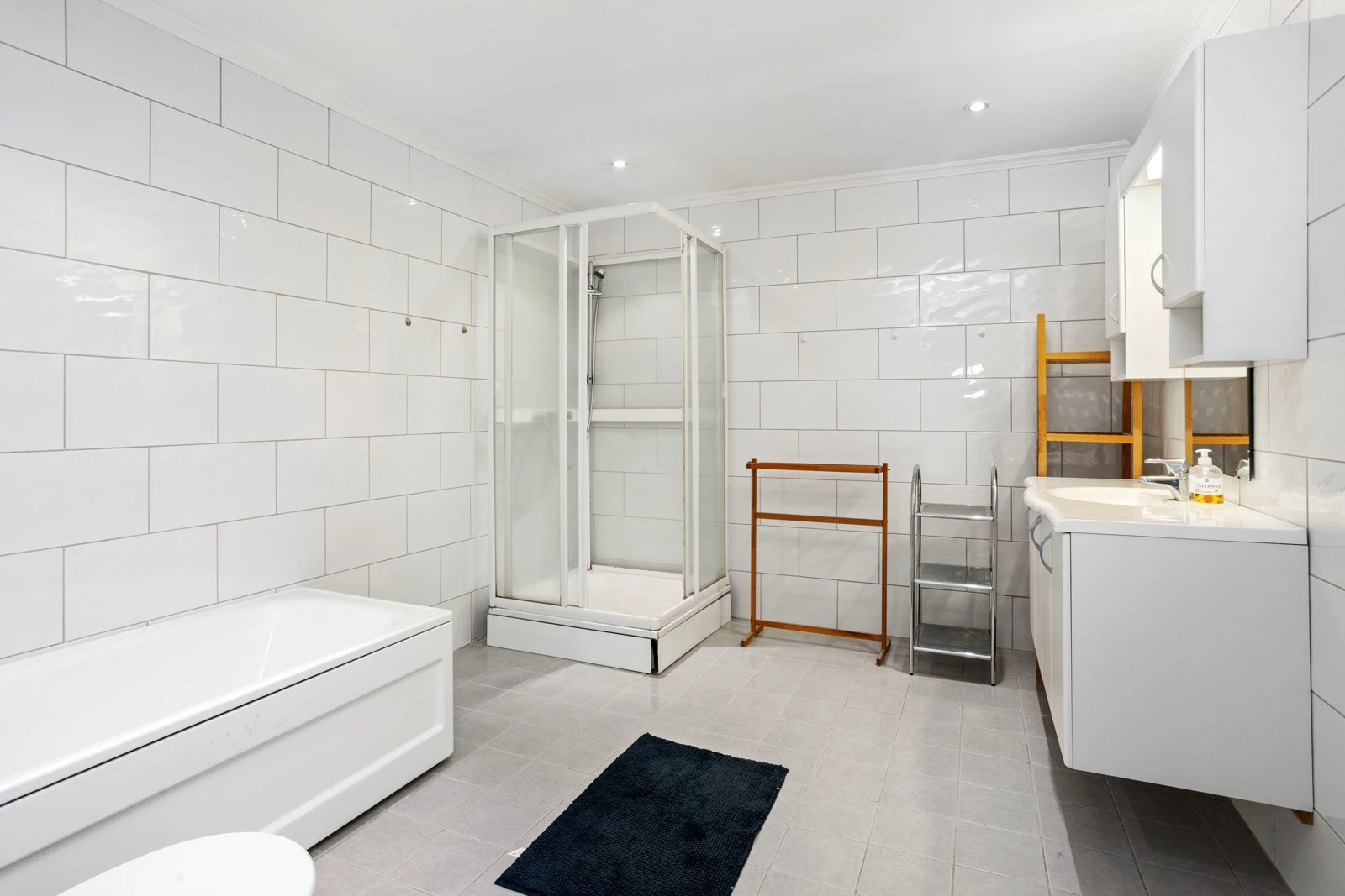 Stort flislagt bad/wc med dusjkabinett og badekar | solid vaskeservant med innredning Galleribilde