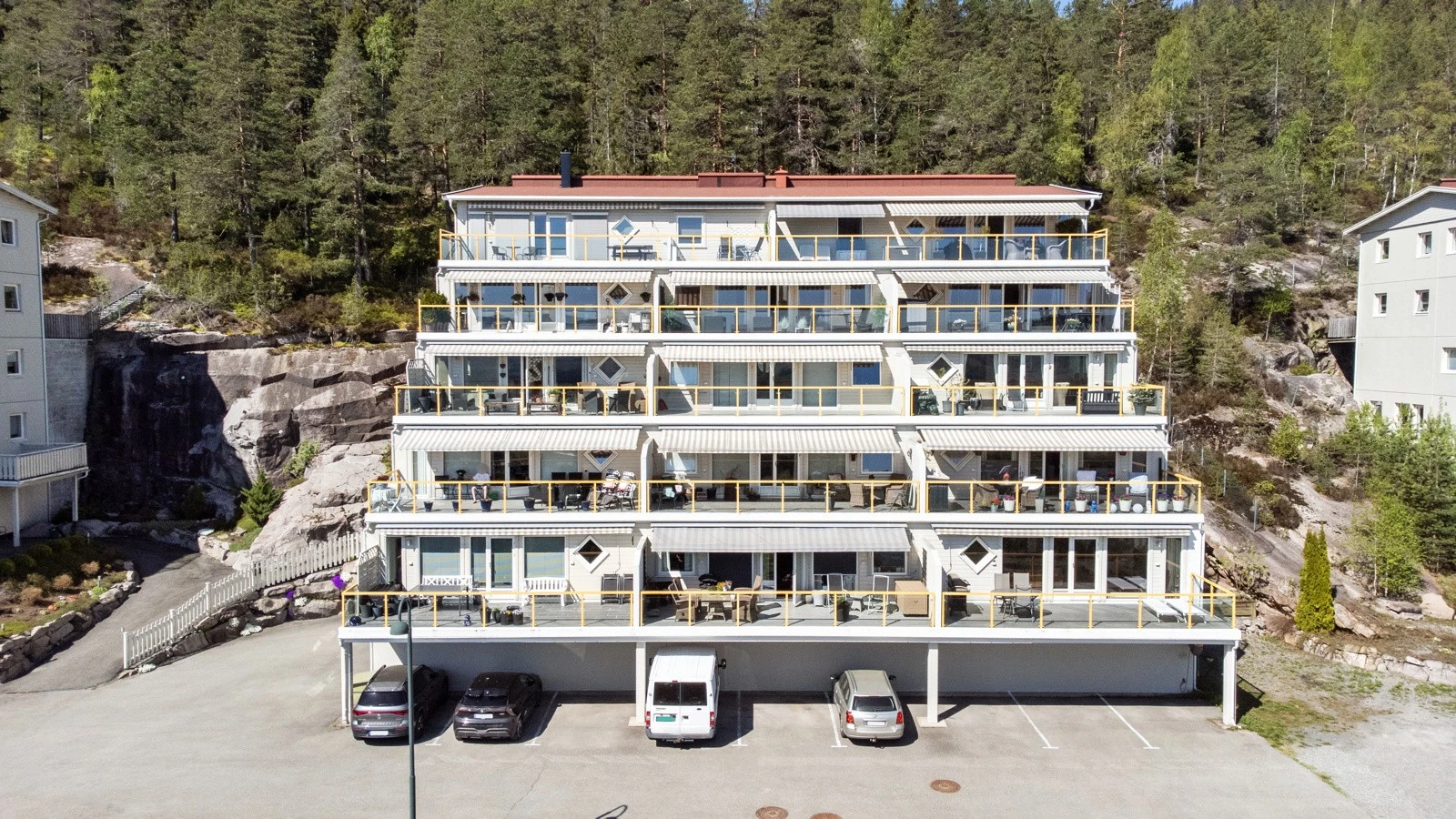 Gjesteparkering delvis under tak i fronten av bebyggelsen Galleribilde