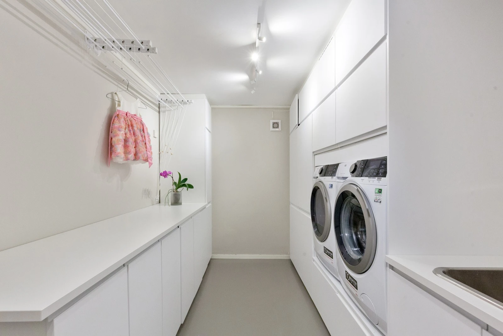 Praktisk rom med med vask, opplegg for vaskemaskin og sluk i gulvet. Overflater er enkle å holde rene, og rommet er godt tilrettelagt for daglige rutiner. Galleribilde