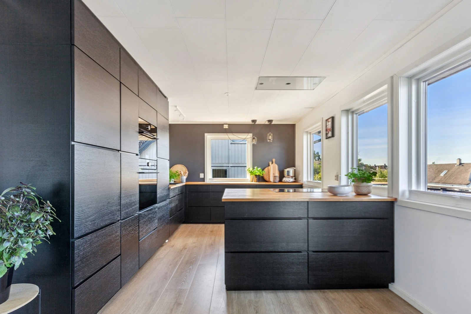 Stilrente og lekkert kjøkken med glatte fronter og en slitesterk heltre benkeplate som gir rause arbeidsflater. Galleribilde