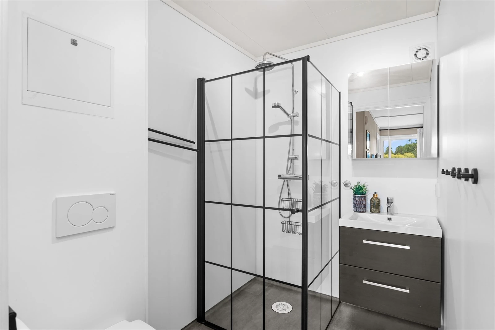 Bad med baderomsinnredning med nedfelt vask, dusjhjørne og toalett. Galleribilde