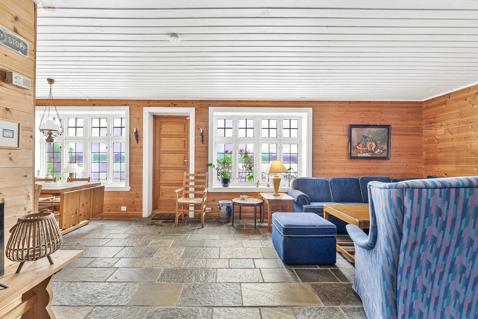 Flott peisestue i 1. etasje med flere bruksmuligheter. Her er det skifergulv og vinduer med bly innfatning. Galleribilde