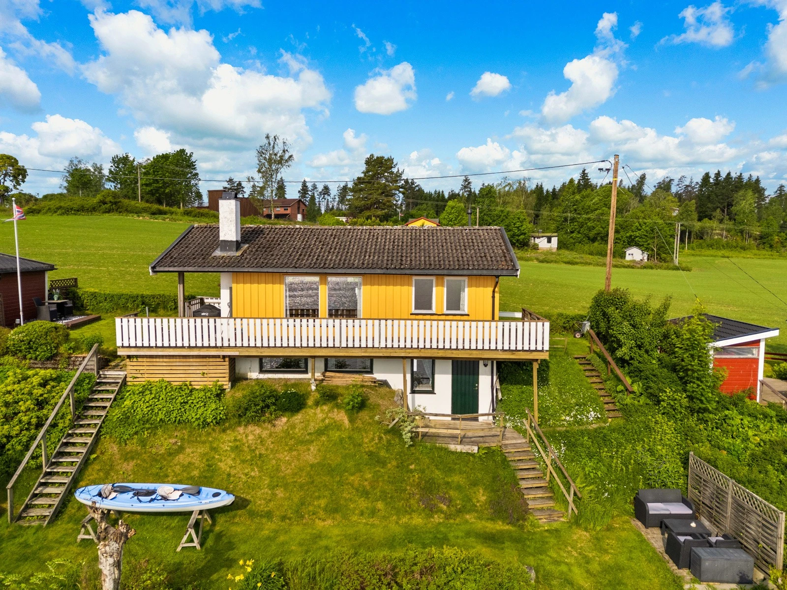 Tomten er skrånende, der to gressplener bindes sammen av trapper i terrenget. Galleribilde