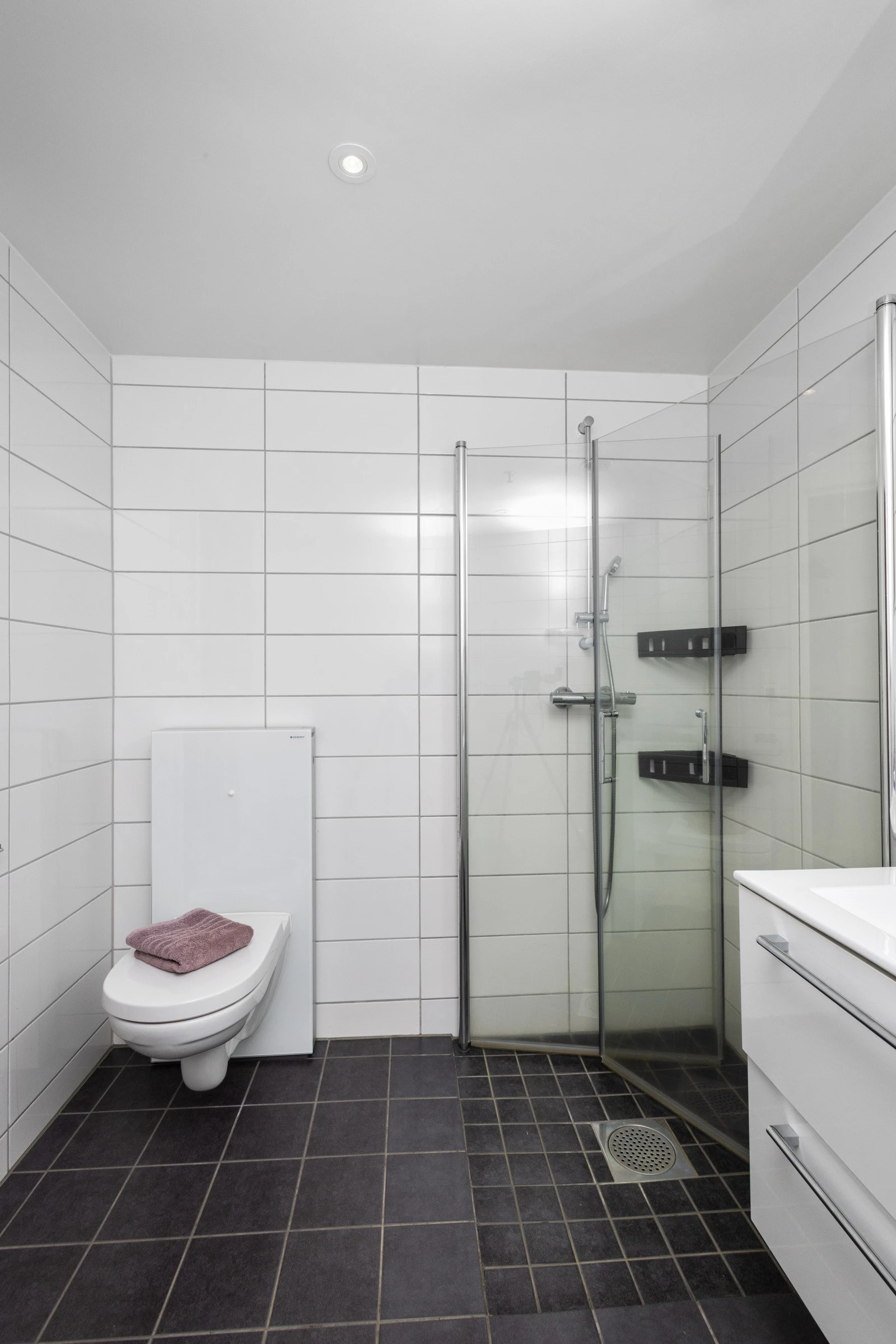 Baderommet inneholder: servant, speil m/belysning, dusjhjørne, veggmontert wc og opplegg for vaskemaskin/trommel. Galleribilde