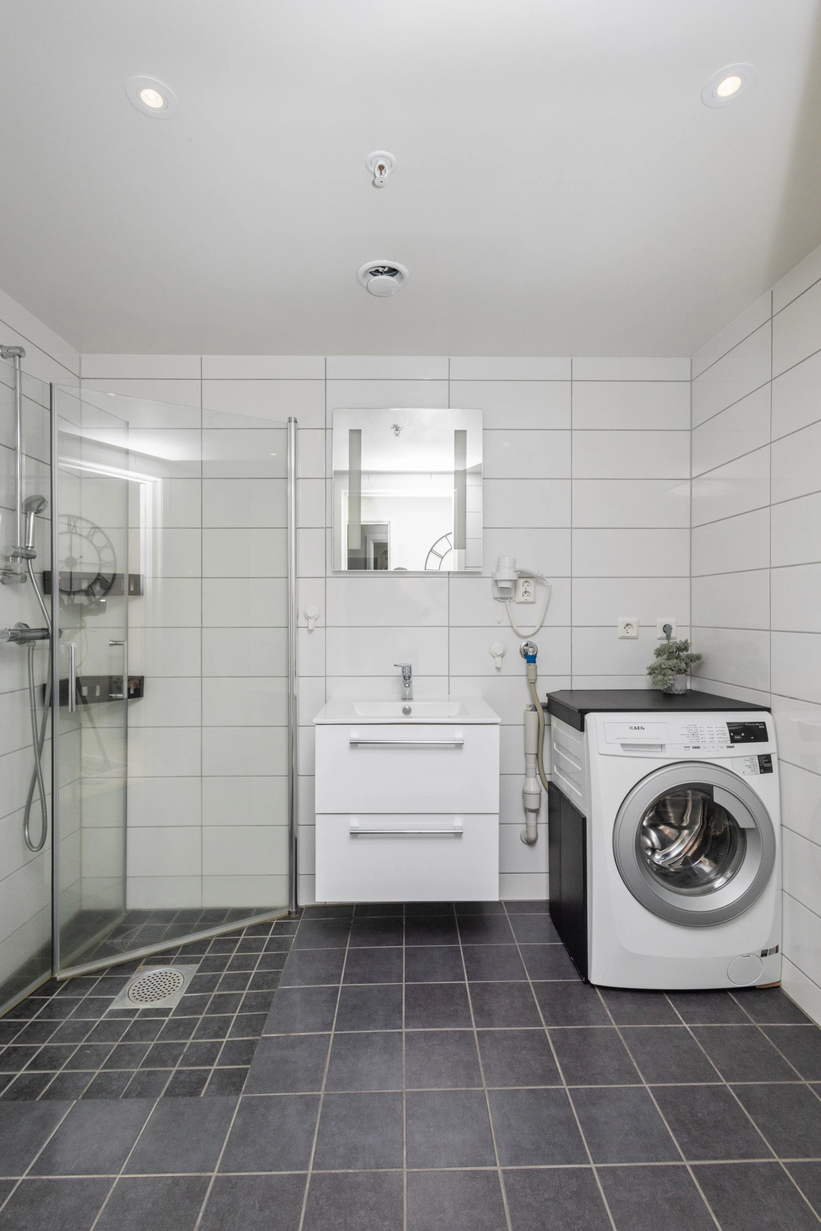 Tidløst, flislagt baderom med varmekabler. Galleribilde