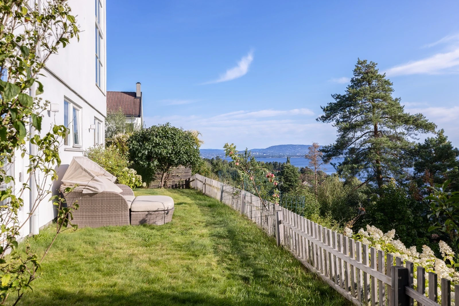 Fra hagen og sokkeletasjen har man utsikt både over tretopper og mot fjorden. I etasjene over er utsynet fritt mot fjorden. 2 forskjellige utsikter, med andre ord. Galleribilde