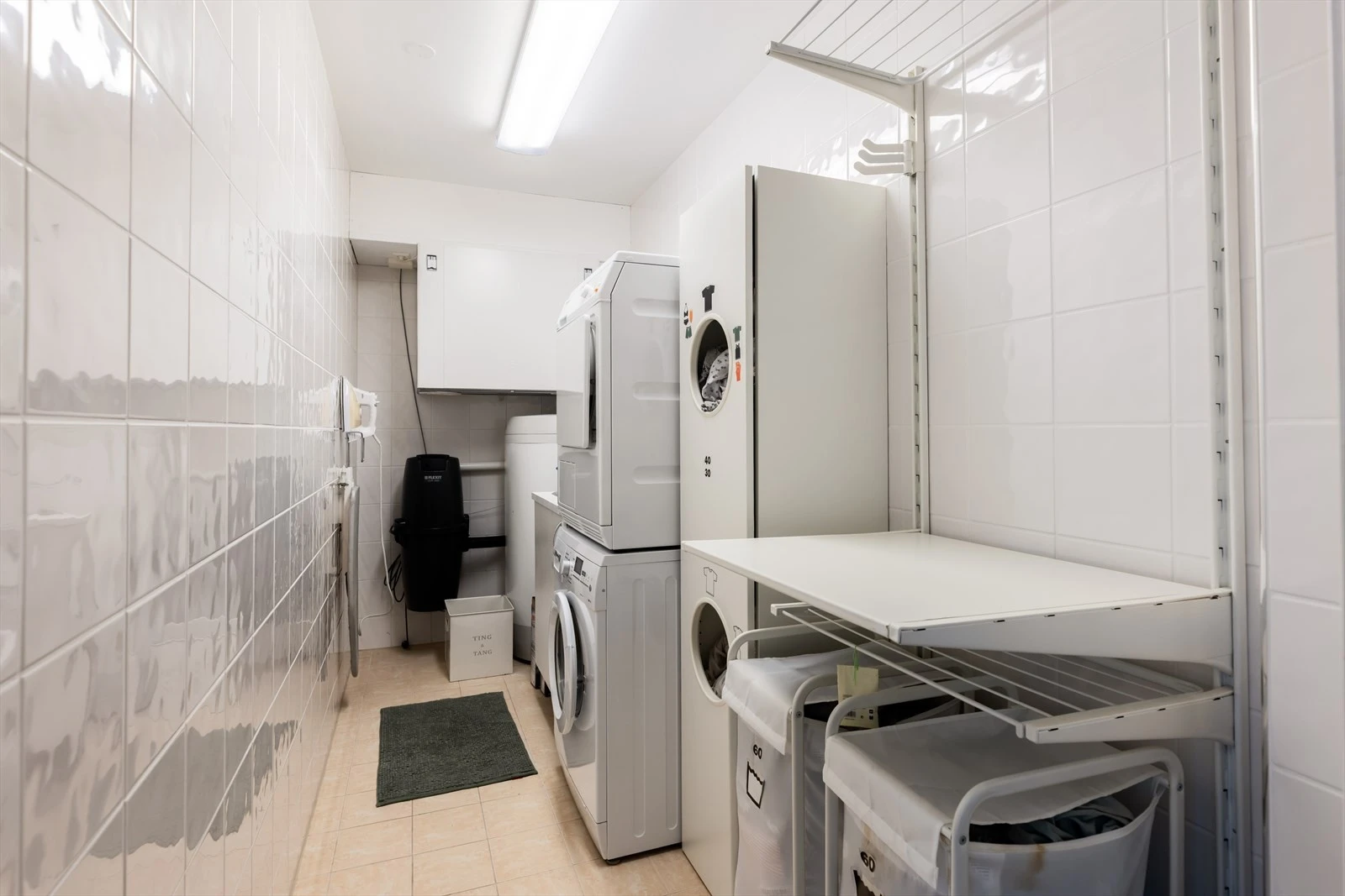 Romslig vaskerom med opplegg for vaskemaskin og tørketrommel. Aggregat for balansert ventilasjon og motor for sentralstøvsuger. Galleribilde