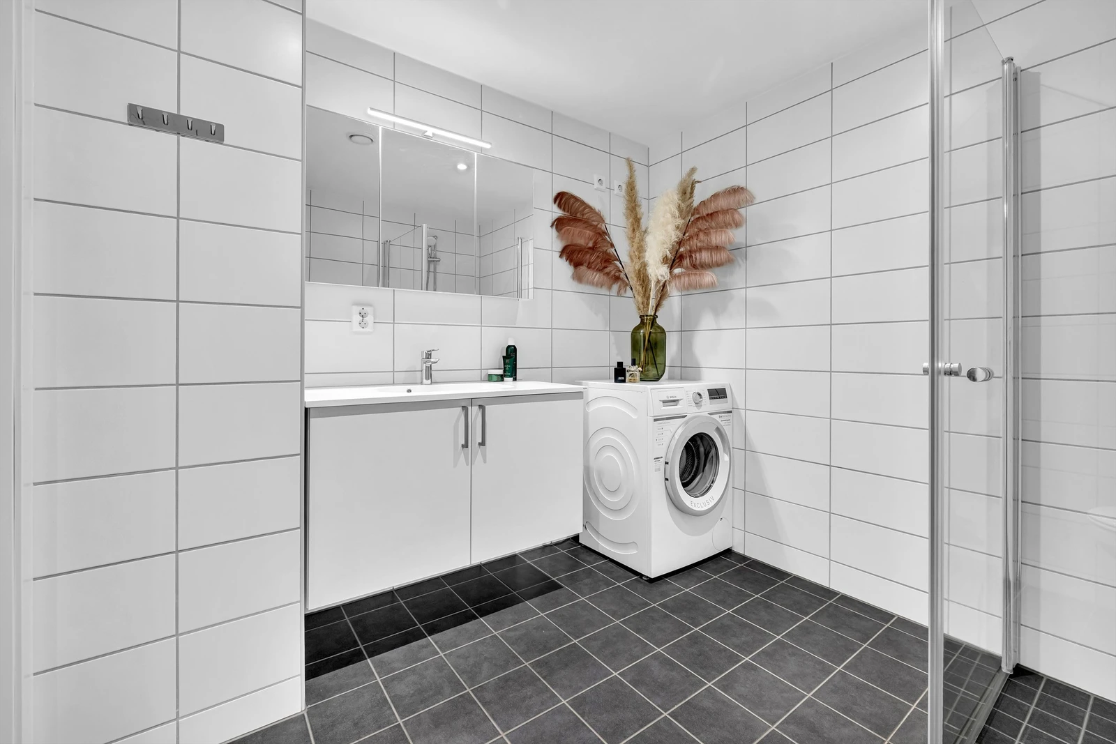 Bad fra 2021 med fliselagt vegger og gulv med varme, opplegg for oppvaskmaskin Galleribilde